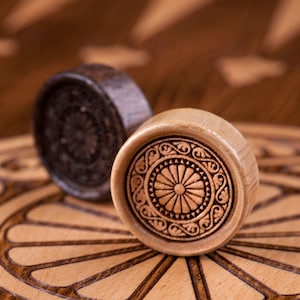 May include: A set of three ceramic mugs with a speckled, matte finish. The mugs are in shades of cream, light gray, and dark gray. Each mug has a simple, minimalist design and a rounded handle. The mugs are likely for coffee or tea.