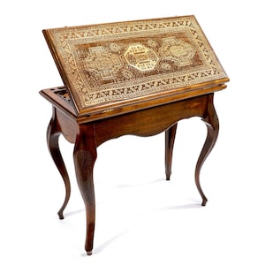 Puede incluir: Una mesa de juego de madera con una tapa abatible que se abre para revelar un tablero de juego. La mesa tiene tallas intrincadas y un acabado marrón oscuro. La parte superior de la mesa está decorada con un patrón geométrico.