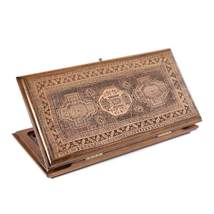 May include: A wooden backgammon set with a detailed, carved design on the playing surface. The set is open, revealing the interior, and features a rich, brown color with intricate patterns. The text "ԳՈՐԾ ԼՈՒՍԻ" is visible on the side.