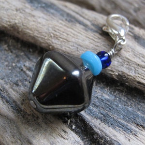 Dije para mochila de regreso a clases, tirador de cremallera con cuentas hexagonales de hematita geométrica y detalles en azul aguamarina y azul rey.