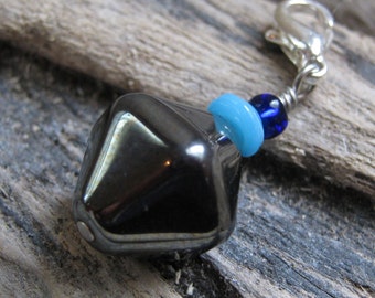 Charm géométrique à tirette avec perles hexagonales en hématite, reflets turquoise et bleu roi