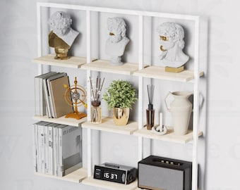 Puede incluir: Estantería blanca de pared con seis estantes. Los estantes están llenos de libros, artículos decorativos y un pequeño reloj. El reloj muestra la hora 15:37.