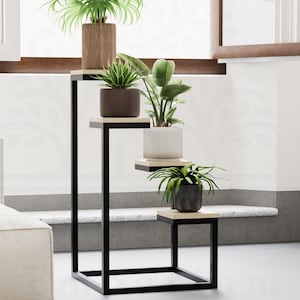 Puede incluir: Un soporte para plantas de metal negro con cuatro niveles, cada nivel con un estante de madera. El soporte está decorado con cuatro plantas en maceta, incluyendo una palmera, una suculenta y dos helechos. El soporte está en una sala de estar moderna con un sofá blanco y una alfombra.
