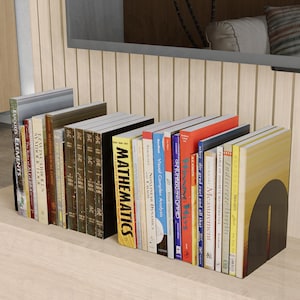 Op de afbeelding: Een set zwarte metalen boekenleggers die een verzameling kleurrijke boeken met verschillende titels vasthouden. De boekenleggers staan op een licht houten plank.