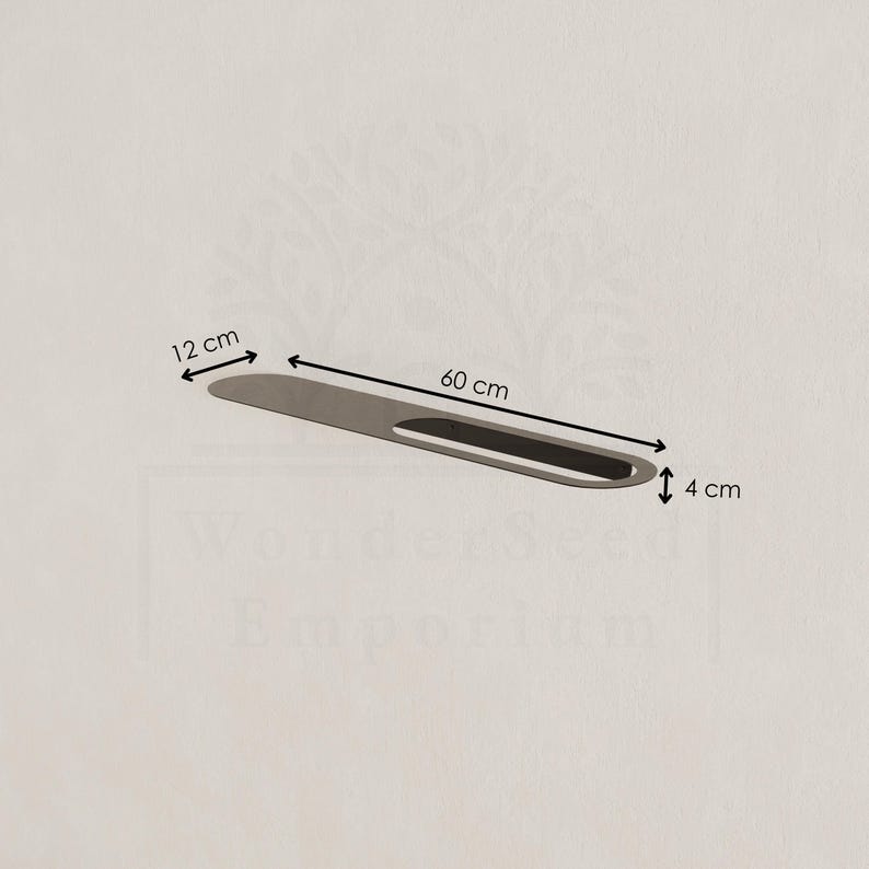 May include: A silver-coloured, elongated object with a black, oval-shaped cutout. The object is 60 cm long, 12 cm wide, and 4 cm thick. The object is on a light beige background.