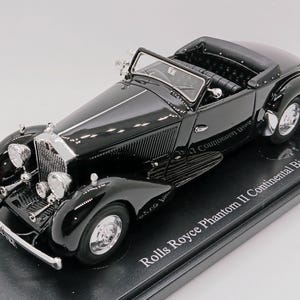 Könnte beinhalten: Schwarzes Rolls Royce Phantom II Continental Binder-Modellfahrzeug aus Metall auf einem schwarzen Display-Sockel. Das Auto hat eine schwarze Karosserie, Chrom-Akzente und einen detaillierten Innenraum.