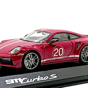 May include: A burgundy Porsche 911 Turbo S model car with white racing stripes and the number 20 on the door. The model sits on a black base with the text "911 Turbo S".