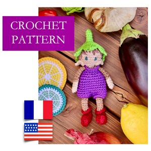 Könnte beinhalten: Häkelanleitung für eine lila und grüne Amigurumi-Puppe mit Hut. Die Puppe ist umgeben von Gemüse und Obst, darunter eine Zitrone, eine Aubergine und Knoblauch.