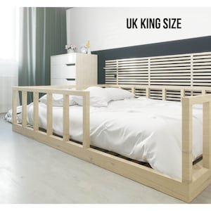 May include: A wooden bed frame with a white mattress and a slatted headboard. The bed is labeled "UK King Size".