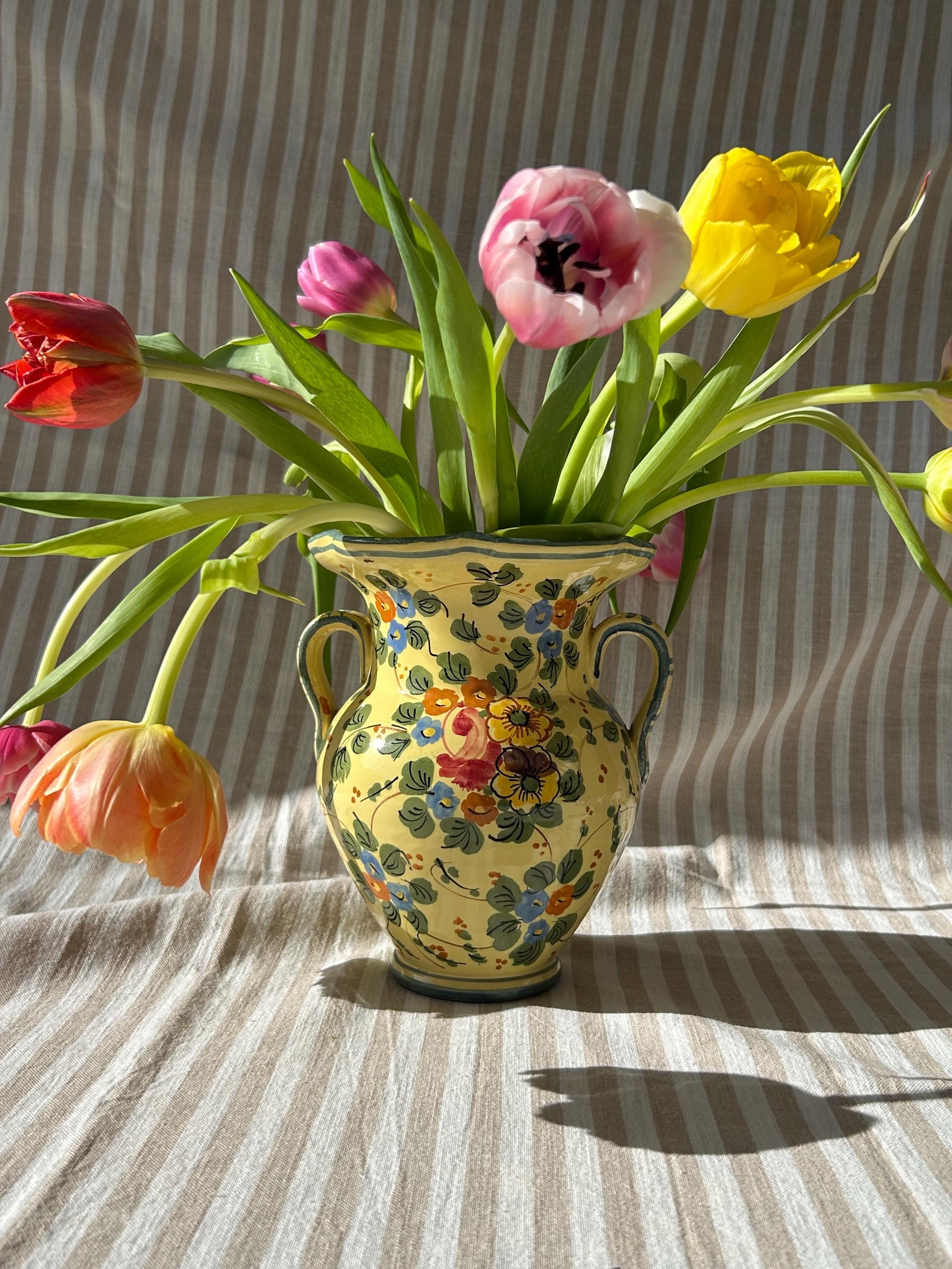 色とりどりの花で飾られた小さなイタリア製陶器の花瓶。イタリア