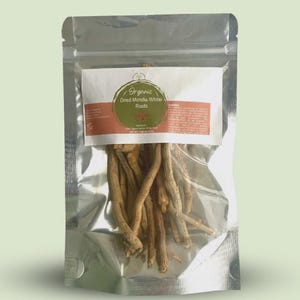 Puede incluir: Una bolsa plateada transparente con raíces secas de Mondia Whitei. Una etiqueta blanca con texto verde y marrón dice "Organic Dried Mondia Whitei Roots". Las raíces son de color marrón claro y tienen una textura rugosa. Peso neto 15 gramos.