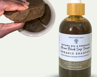 May include: A bottle of Batana Oil & Rosemary African Black Soap Shampoo with a white label and a wooden cap. The image also shows a bowl with chunks of brown soap.