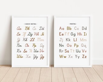 May include: Two white framed posters with the alphabet in cursive and print. The cursive alphabet is in brown, black, and gray. The print alphabet is in brown, black, gray, and beige.