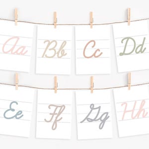 May include: Eight printable flashcards with cursive letters A through H on a white background. Each card has a different color for the letter, including pink, brown, light green, blue, and gray.