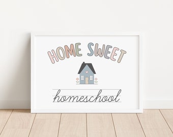 May include: A white framed print with the text "HOME SWEET homeschool" in a rainbow of colors. A small blue house with a heart on the door is in the center of the print.