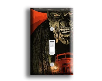 May include: A decorative light switch cover featuring a menacing face with sharp teeth and red eyes against a dark background. The design includes a red train and a dark, ominous forest. The switch is in the "off" position.
