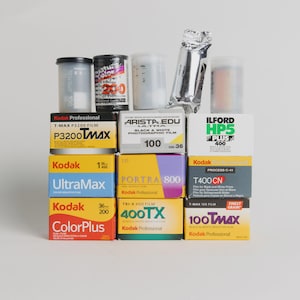 May include: A collection of various film rolls and boxes, including Kodak ColorPlus, UltraMax, and T-Max films, along with Ilford HP5 Plus and Arista.EDU Ultra film. The assortment features both color and black and white film options.