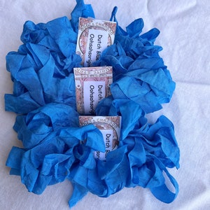 May include: Two bundles of blue silk ribbon, each with a label that reads "Dutch Blue Oohsahsorigin" and "KOETS CHANDON".