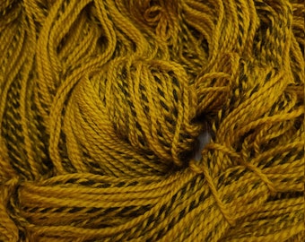 May include: A skein of yarn with a yellow and black color combination. The yarn is twisted and has a textured appearance.