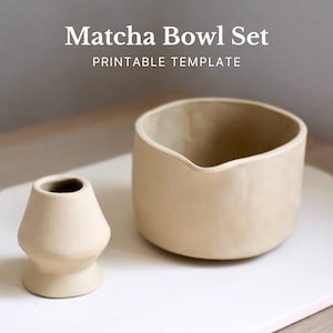 Puede incluir: Un juego de cuencos de matcha beige con un pequeño soporte redondeado para batidor y un cuenco más grande con boquilla. El texto "Matcha Bowl Set Printable Template" se muestra en la parte superior de la imagen.