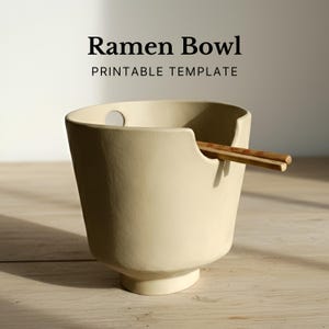 Könnte beinhalten: Eine cremefarbene Ramen-Schüssel mit einzigartigem Design, mit einer Aussparung für Essstäbchen. Die Schüssel hat einen abgerundeten Boden und eine breite Öffnung. Der Text "Ramen Bowl PRINTABLE TEMPLATE" wird oben angezeigt.