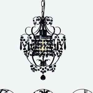 May include: Black chandelier with crystal accents. The chandelier has a traditional design with a round, open-work frame and multiple tiers of crystals.