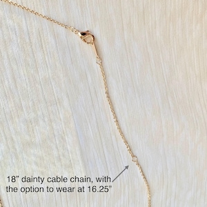 May include: A delicate gold-colored cable chain necklace. The necklace is 18 inches long, with an option to wear it at 16.25 inches. The chain has a lobster clasp closure.