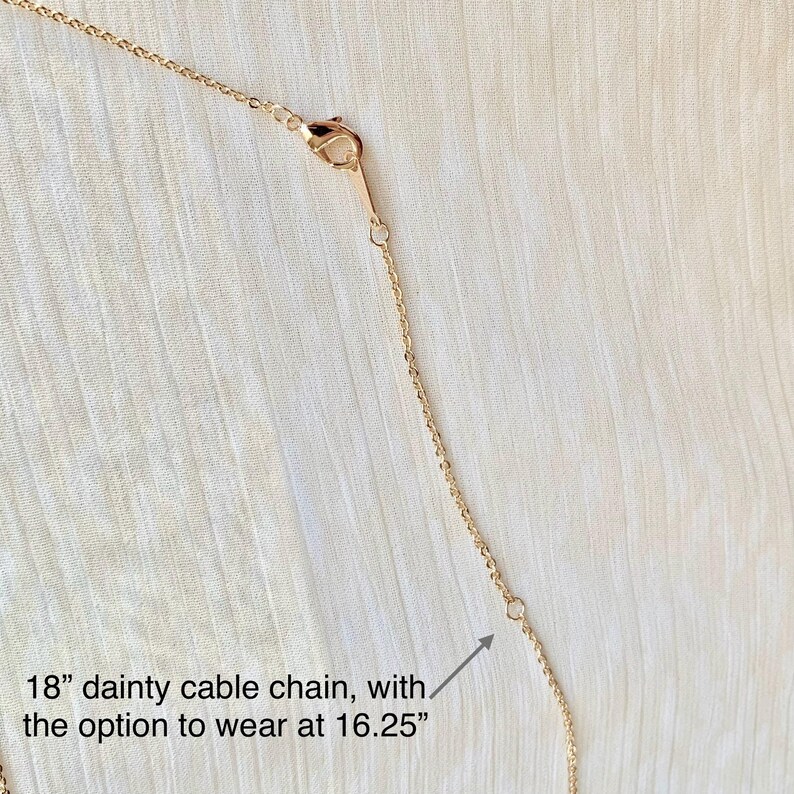 May include: A delicate gold-colored cable chain necklace. The necklace is 18 inches long, with an option to wear it at 16.25 inches. The chain has a lobster clasp closure.