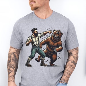 Camiseta unisex "Hombre contra oso", camiseta con gráficos de vida silvestre, regalo para amantes de la naturaleza y la aventura, camiseta para acampar al aire libre y senderismo, camiseta con animales salvajes.