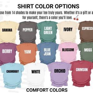 May include: A color chart displaying 14 short-sleeve t-shirts in various shades labeled Banana, Pepper, Light Green, Ivory, Espresso, Berry, Yam, Blue Jean, Blossom, Moss, Chambray, White, Orchid, and Crimson, with the text SHIRT COLOR OPTIONS.