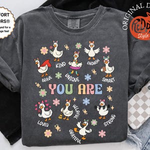 May include: Dark gray sweatshirt with a graphic of cartoon geese with encouraging words like "brave," "kind," and "strong." The words "YOU ARE" are in the center. The sweatshirt has a soft, vintage feel.