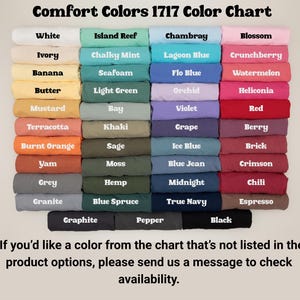 Op de afbeelding: Een kleurenkaart met de titel "Comfort Colors 1717 Color Chart" met een verscheidenheid aan stoffen kleuren. Kleuren zijn onder meer wit, ivoor, banaan, boter, mosterd, terracotta, verbrand oranje, yam, grijs en graniet. De kaart bevat ook tekst: "Als je een kleur uit de tabel wilt die niet in de productopties staat, stuur ons dan een bericht om de beschikbaarheid te controleren."