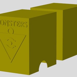Peut inclure: Une boîte en deux parties de couleur moutarde avec le mot "MONSTERS" et un symbole triangulaire gravé sur le devant. La boîte a une découpe incurvée sur le bord inférieur. Le design est simple et géométrique.