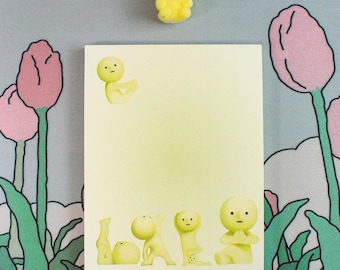 May include: A yellow notepad with a green gradient background. The notepad has a yellow cartoon character on the top and a row of yellow cartoon characters on the bottom. The notepad is surrounded by green leaves and pink tulips.