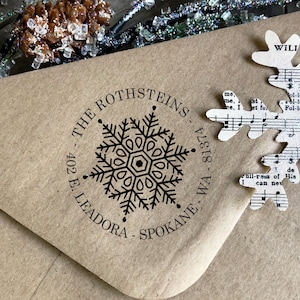 May include: A brown paper envelope with a black and white snowflake design rubber stamp. The stamp reads "The Rothsteins - 402 E. Leadora - Spokane, WA - 81374".