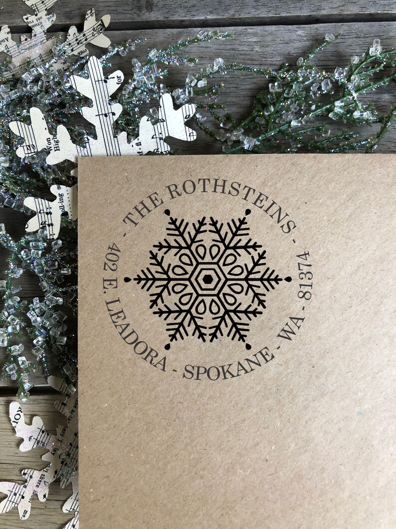 May include: A brown paper envelope with a black snowflake design and the text "THE ROTHSTEINS 402 E. LEADORA - SPOKANE - WA - 81374" printed on it.