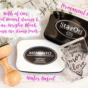 May include: Two ink pads, one black and one white, with the brand names "StazOn" and "Memento" printed on them. A clear acrylic stamp with the text "Sending you more love" is also shown. The text "Permanent Ink" and "Water Based" is written in pink on the image.