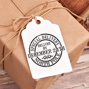May include: A white gift tag with a black and white circular stamp that reads "Special Delivery Deliver by December 24th North Pole".