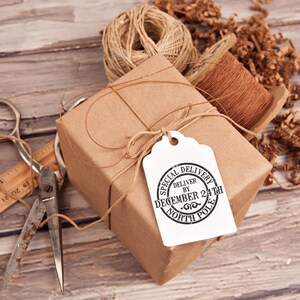 May include: A brown paper wrapped gift box tied with twine and a white tag that reads "Special Delivery Deliver by December 24th North Pole".