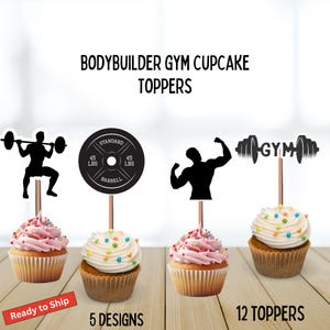 May include: Cupcakes with pink and white frosting, topped with gym-themed toppers. The toppers include silhouettes of a weightlifter, a barbell weight, a bodybuilder flexing, and a barbell with the word "GYM". The text reads "BODYBUILDER GYM CUPCAKE TOPPERS".