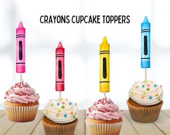 Puede incluir: Cuatro cupcakes con adornos en forma de crayones rosas, rojos, amarillos y azules. Cada cupcake tiene un remolino de glaseado y chispas de colores. El texto "CRAYONS CUPCAKE TOPPERS" está en la parte superior, con "6 DESIGNS" y "12 TOPPERS" en la parte inferior.