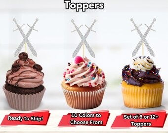 May include: Three cupcakes decorated with silver glitter sword cupcake toppers. The cupcakes are frosted in pink, brown, and white. The text on the image reads "Sword Cupcake Toppers", "Ready to Ship!", "10 Colors to Choose From", and "Set of 6 or 12+ Toppers".