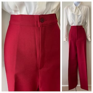 Può includere: Un paio di pantaloni rossi a vita alta e gamba larga. I pantaloni hanno una chiusura con bottoni e una vestibilità su misura. Sono abbinati a una camicetta bianca con fiocco.