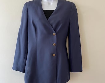 May include: A dark blue blazer with a long, asymmetrical hemline and four brown buttons down the front.