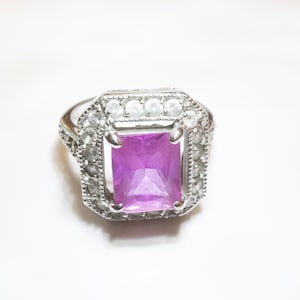 925 silver ring, pink sapphire, and also clear stones, maybe topaz surrounding. Size 7.  Stamped FAS and 925.