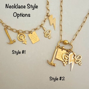 May include: Two gold necklaces with different charms. The first necklace has a hammer, a feminist symbol, and a small sign that says "This is what a feminist looks like". The second necklace has a hammer, a feminist symbol, a lightning bolt, a snake, and a sign that says "Pay me like a white man".
