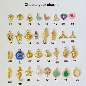 May include: A selection of gold-tone charms with various designs, including hearts, fish, seashells, and a starfish. The charms are numbered 44 through 75.