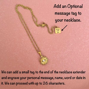 May include: A gold-tone chain necklace featuring a sunburst pendant with a central clear stone. The necklace includes an extender chain with a small square tag engraved with the text "always with you." Text on image: Add an Optional message tag to your necklace.