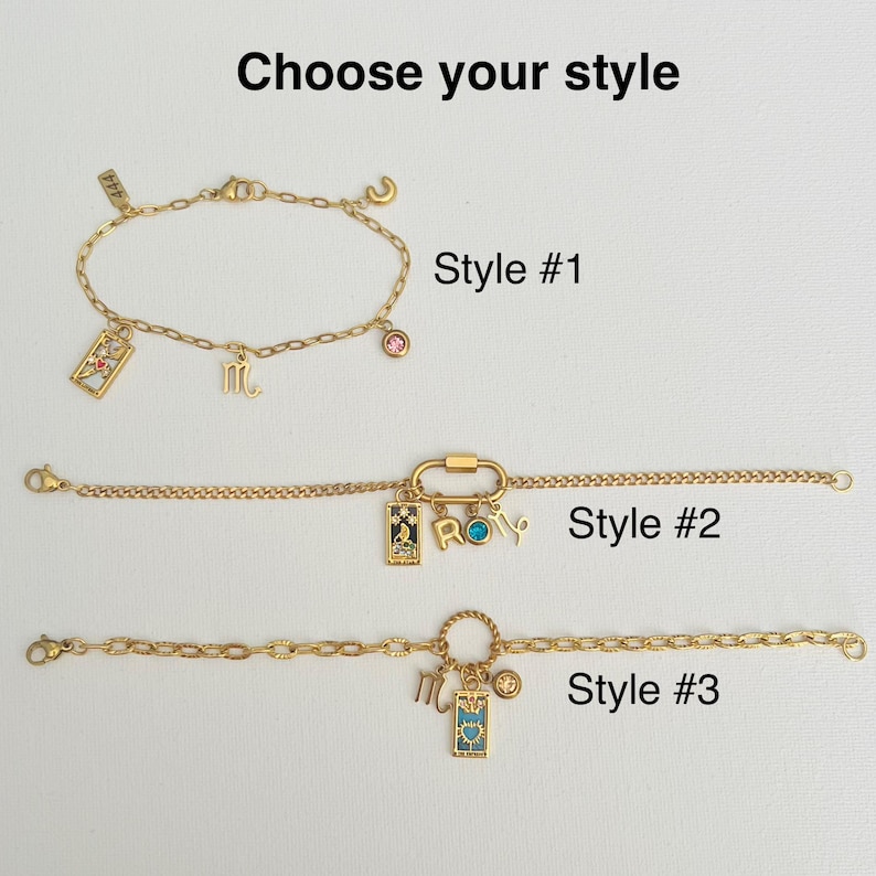 May include: Three gold chain bracelets with different charms. The first bracelet has a pink stone, a letter "C" charm, and a tarot card charm. The second bracelet has a carabiner clasp, a tarot card charm, and a charm that says "ROMY". The third bracelet has a round charm, a tarot card charm, and a letter "M" charm. The bracelets are labeled "Style #1", "Style #2", and "Style #3".
