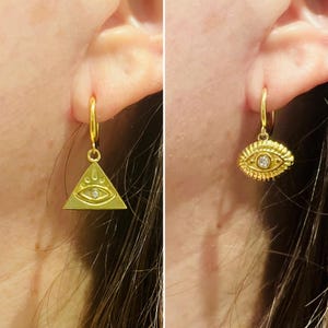Op de afbeelding: Twee gouden oorringen met een klein diamanten oogbedel. De oorring aan de linkerkant is driehoekig en de oorring aan de rechterkant is druppelvormig.